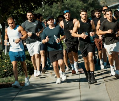 A run club running down a sidewalk with AquaFlo bottles