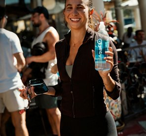 A woman holding an AquaFlo bottle at a wellness event